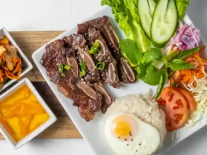 Plate with grilled beef on rice with vegetables