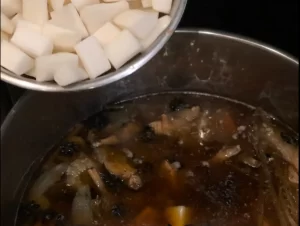 Daikon white radish is being added to the oxtail pho broth