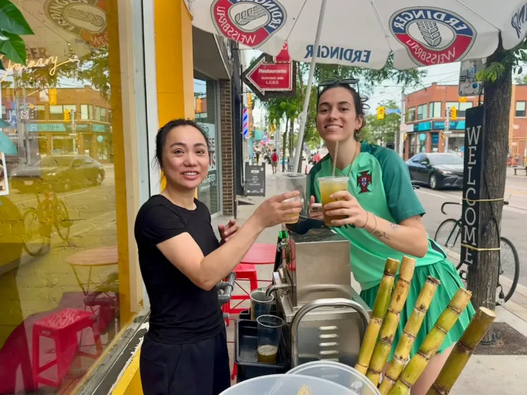 Linda and Bela cheer with sugarcane juice on Dundas St W